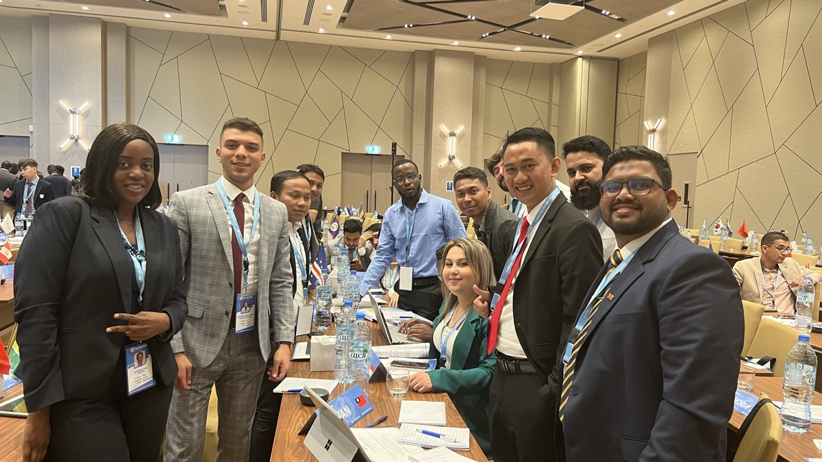 Delegates in session at the Best Diplomats international conference in Dubai, with country flags on the tables
